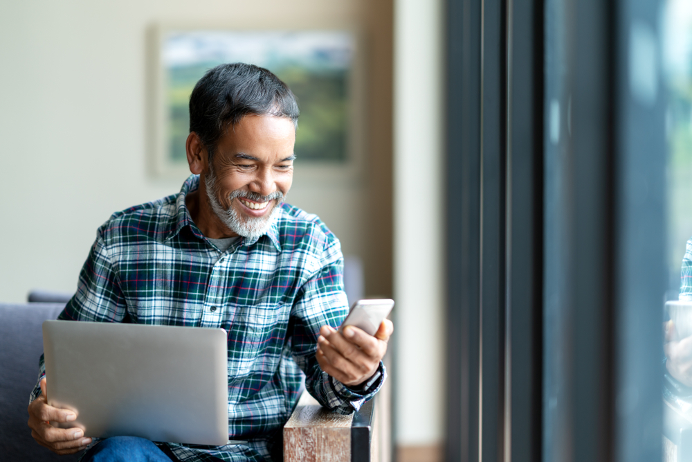 satisfied client checking his phone to review a service. ProgressionLive customer app satisfaction